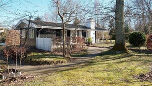 A single-story house with a covered porch, a chimney, and a small garden area. - 5 Person Holiday Home in Melby (Melby)