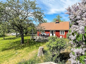 A red house with a tiled roof, a deck, and a lawn. - 4 Star Holiday Home in Torhamn (Torhamn)