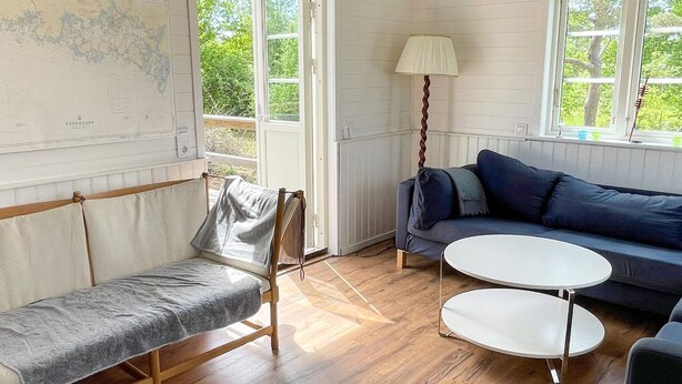 Ett rum med en säng, en soffa, ett runt bord och en lampa.