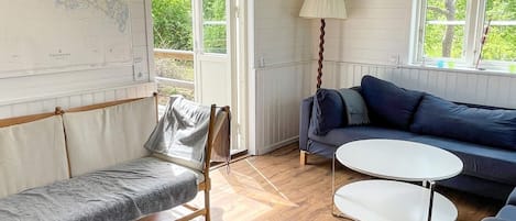 A room with a bed, a sofa, a round table, and a lamp.