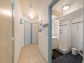 Bathroom features a shower area, toilet, and sink with mirror.