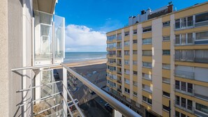 A balcony with a clear view of the beach and adjacent buildings. - Apartment With 2 Bedrooms and sea View (Middelkerke)