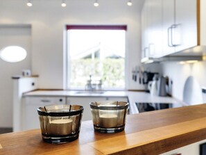 A modern kitchen with two glass candle holders on a wooden countertop.