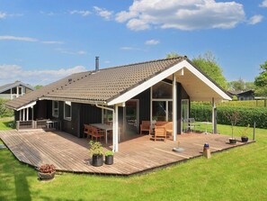A modern house with a large deck, a covered patio, and a chimney. - 4 Star Holiday Home in Hadsund (Hadsund)