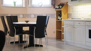 A kitchen with a dining table and chairs, a wine rack, and cabinets. - Holiday Apartment Pia Stadfeld (Mehring)