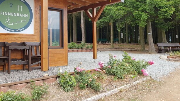 A wooden structure with a sign reading "GESUNDHEITSPARK FINNENBAHN MEHRING - POLICCH". - Holiday Apartment Pia Stadfeld (Mehring)
