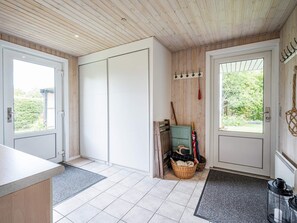 A room with a sliding door, a wooden ceiling, a small basket, and a door with a coat rack. - 6 Person Holiday Home in Tarm (Tarm)