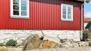 A red building with two white-framed windows and a stone foundation. - 4 Person Holiday Home in Bleket-by Traum (Bleket)