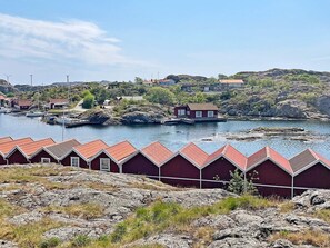A coastal area with red-roofed buildings, a marina, and rocky terrain. - 4 Person Holiday Home in Bleket-by Traum (Bleket)