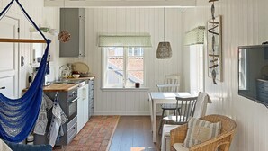 A rustic kitchen with a hanging hammock, a dining table with chairs, and a large window. - 4 Person Holiday Home in Bleket-by Traum (Bleket)