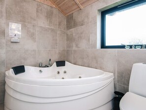 A modern bathroom with a freestanding bathtub, a window with a view, and a tiled wall. - 5 Star Holiday Home in Fano (Fano)