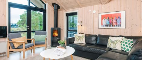 A cozy living room with a fireplace, a sofa, a chair, and a coffee table.
