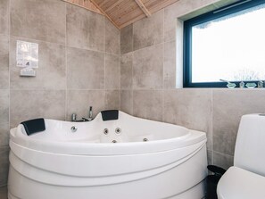 A modern bathroom with a freestanding bathtub, a window with a view, and a tiled wall. - 5 Star Holiday Home in Fano (Fano)