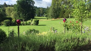Ein gepflegter Golfplatz mit akkurat gestutzten Rasenflächen, Bäumen und dekorativen, kugelförmigen Objekten.