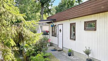 A single-story building with a brown roof, white walls, and a small porch area.