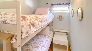 A bunk bed room with a window, a small table, and wall decorations. - 4 Person Holiday Home in Hollviken (Hollviken)