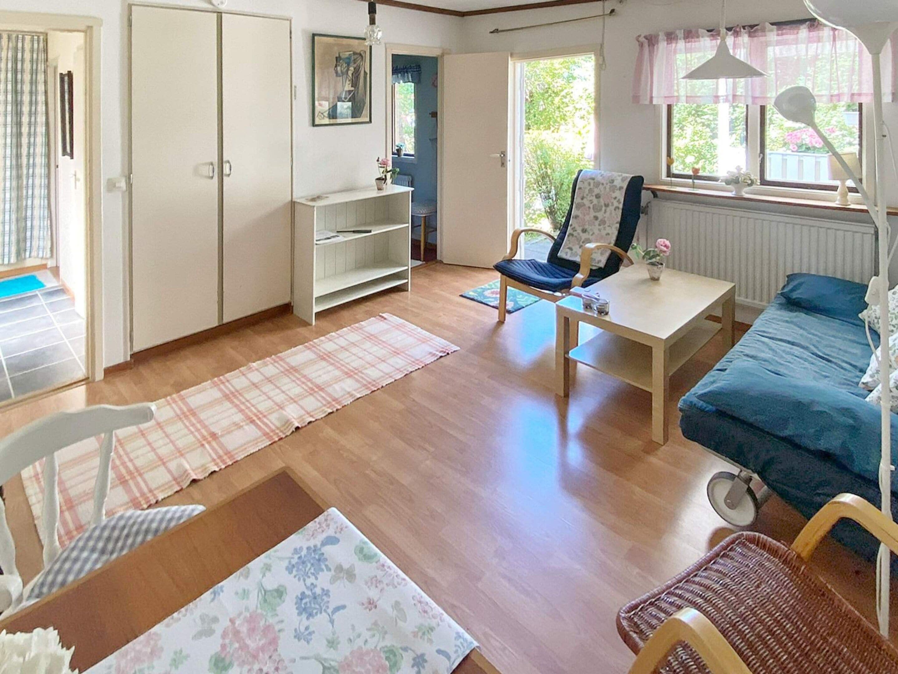 Una habitación con una cama, una silla, una mesa, un radiador y una ventana.