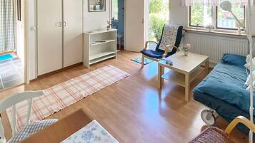 Una habitación con una cama, una silla, una mesa, un radiador y una ventana.