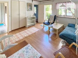 Una habitación con una cama, una silla, una mesa, un radiador y una ventana.