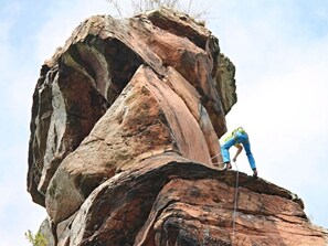 A person climbing a large rock formation.