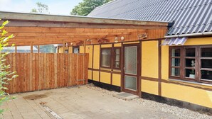 A wooden structure with a tiled roof and a yellow facade. - 6 Person Holiday Home in Rodby (Rodby)
