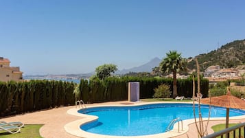 Une piscine avec vue sur la montagne et la mer.