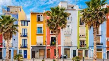 Une rangée de bâtiments colorés, dotés de balcons et bordés de palmiers.