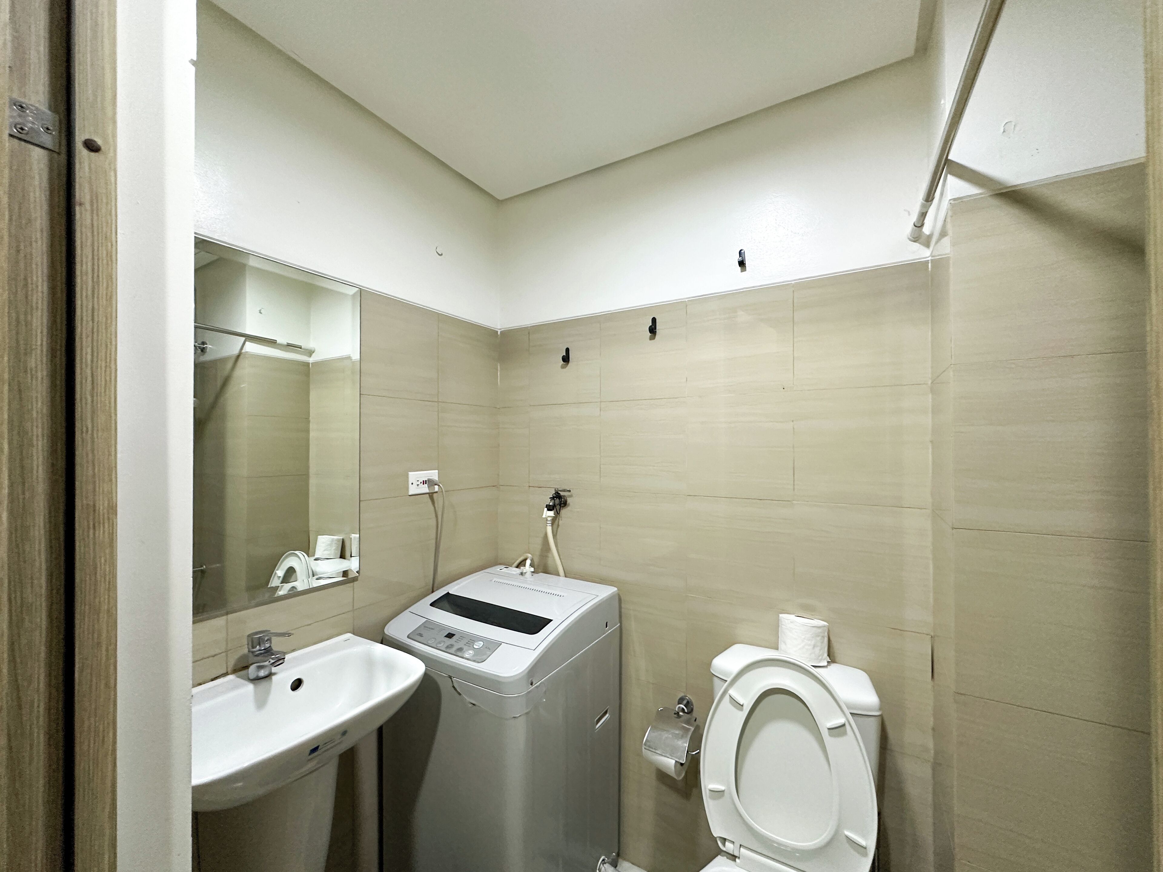 Un baño con lavamanos, inodoro y lavadora.