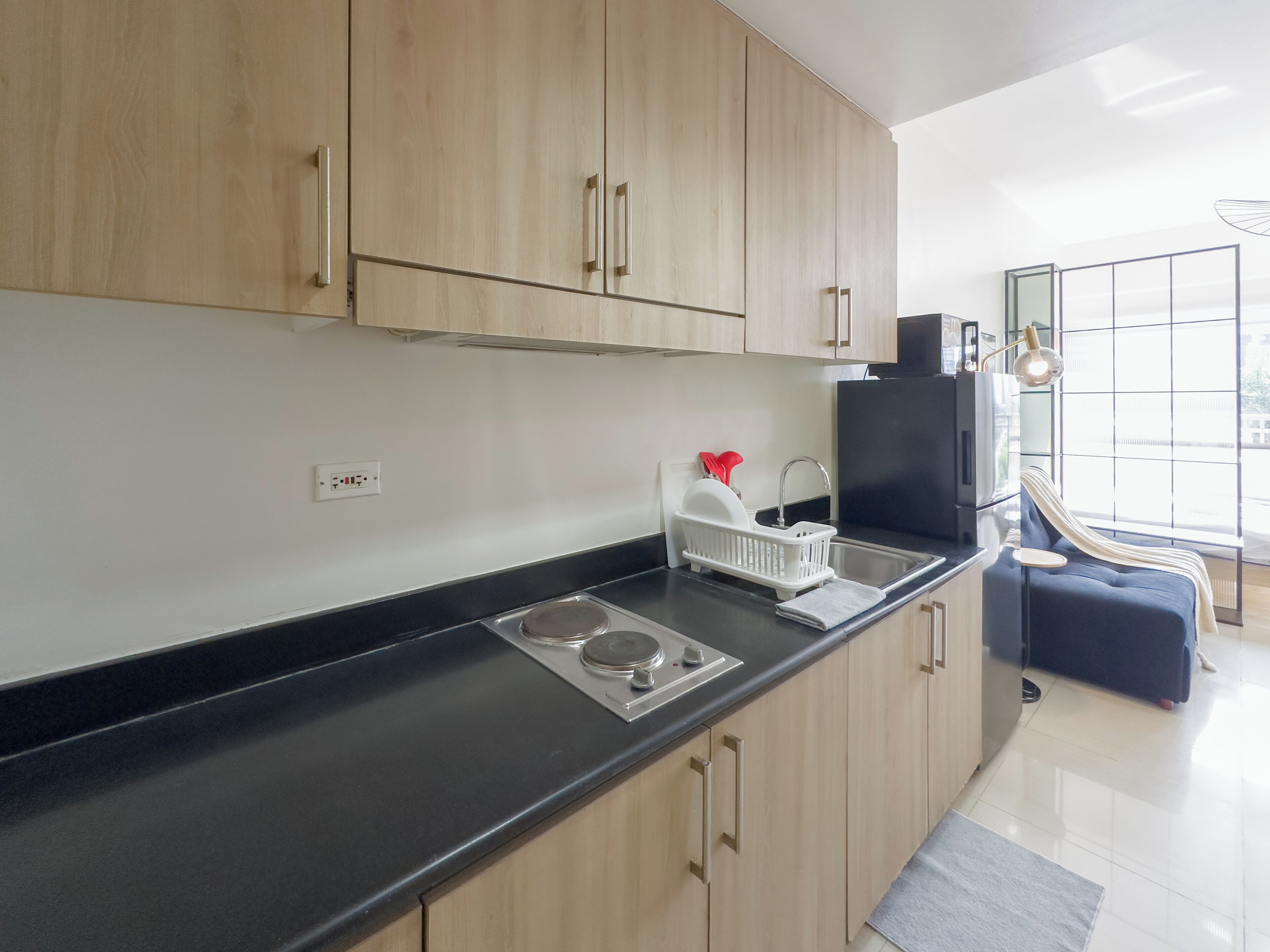 Una cocina moderna con armarios de madera, encimera negra y estufa empotrada.