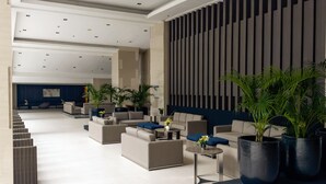 Un hall d’entrée moderne, doté de canapés, de tables et de plantes en pot.