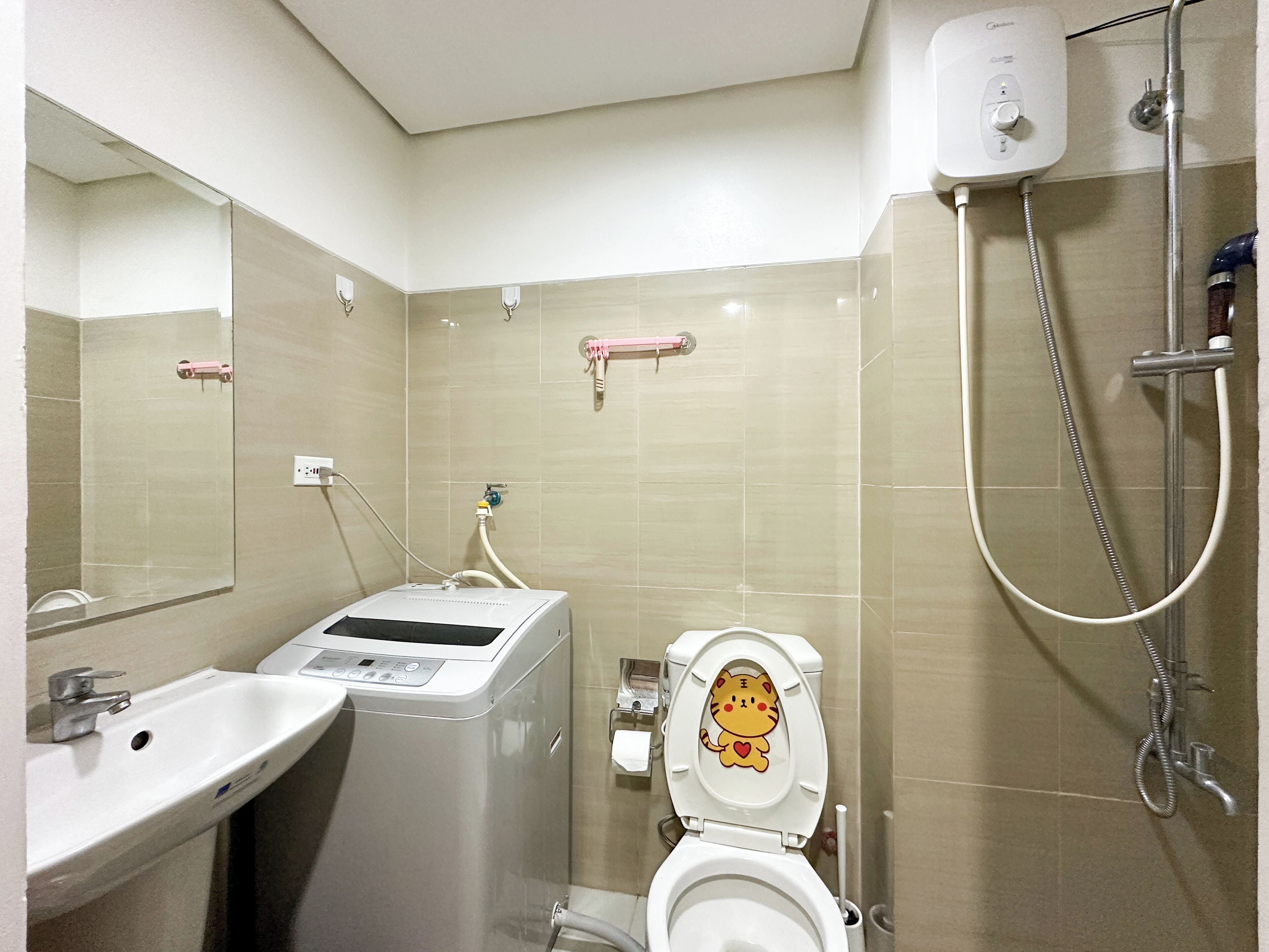 A bathroom with a toilet, sink, and shower.