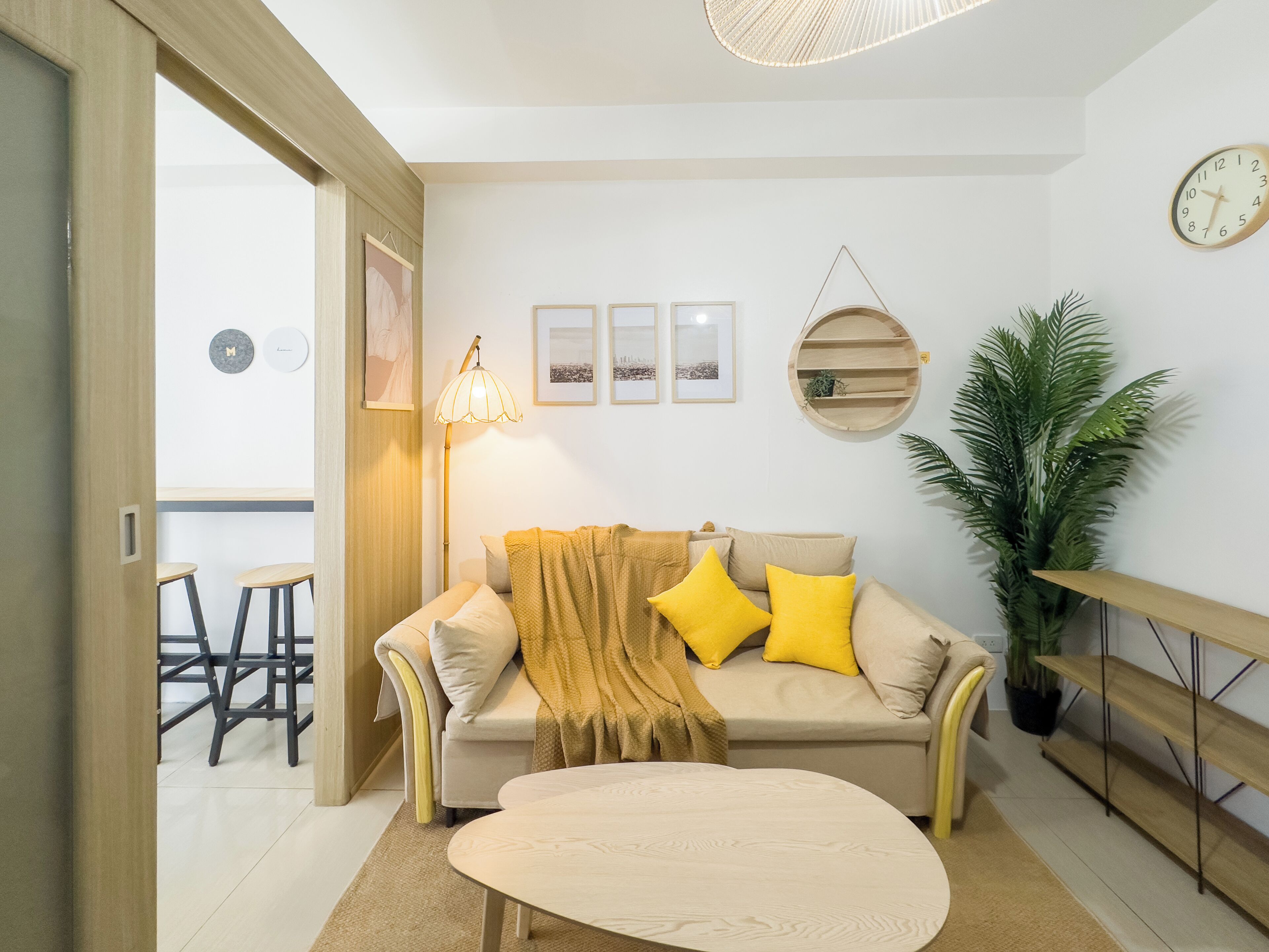 A modern living room with a sofa, a coffee table, a lamp, and a potted plant.