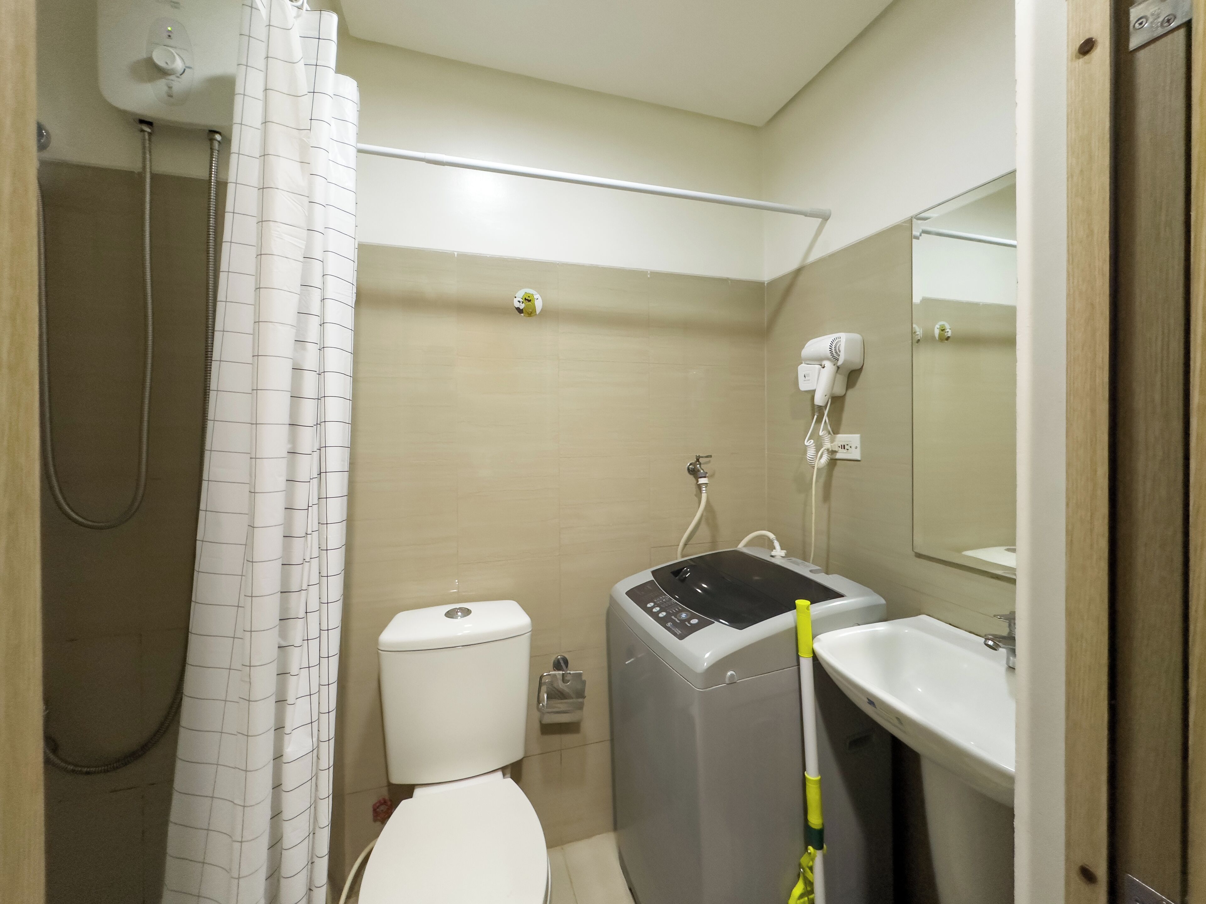 Ein Badezimmer mit Toilette, Dusche, Fön und Waschbecken.