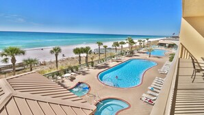 Ein Resort mit einem großen Schwimmbad, einem kleineren Pool und Blick auf den Strand.