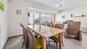 Et moderne spiseområde med et træbord, fletstole og en læderstol.
