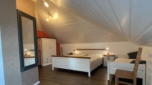 Un dormitorio con cama, mesita de noche, silla y armario.