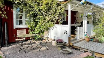 A house with a covered porch, a wooden bench, and a potted plant.