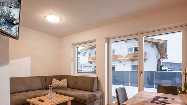 Un salon moderne avec un canapé, une table en bois et un coin repas.