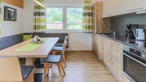 Une cuisine moderne avec des meubles en bois, un four encastré et une machine à café.