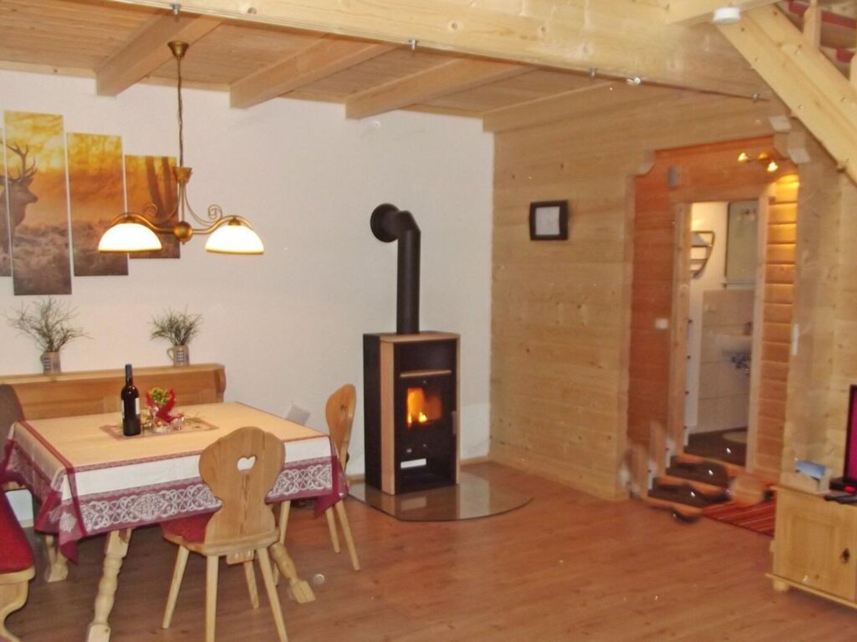 A cozy dining area with a wooden table, chairs, and a fireplace.