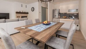 A modern living space with a dining area, kitchen, and seating area.