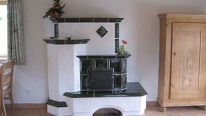 Una habitación con chimenea, un armario de madera y una silla.