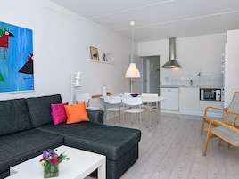 Una sala de estar moderna con un sofá gris, una mesa de centro blanca y un cuadro llamativo.