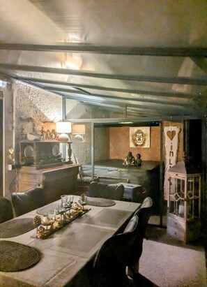 Enjoy meals in this cozy dining area with a long table for two, a side table, and a wall-mounted lamp.