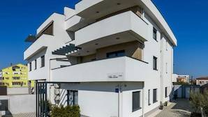 A modern multi-story building with balconies, a gated entrance, and a clear sky. - Villa Dora - Apt 3 "grijs" (Pula)