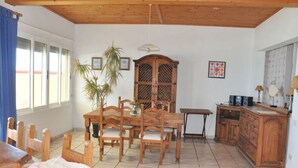 A dining area with a wooden table and chairs, a cabinet, and a small table with speakers. - Casa Mar y Sol aan Zee (Los Llanos de Aridane)