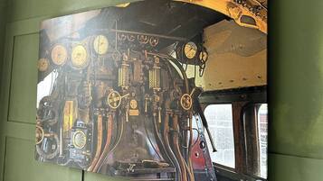 Een gedetailleerde muurschildering van het interieur van een oude trein, inclusief meters en bedieningselementen.