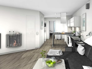 Ett modernt, minimalistiskt vardagsrum med en grå soffa, ett soffbord med en skål med äpplen och en tv som är monterad på väggen.