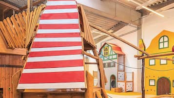 Un área de juegos con una estructura para escalar y casas de juego coloridas.