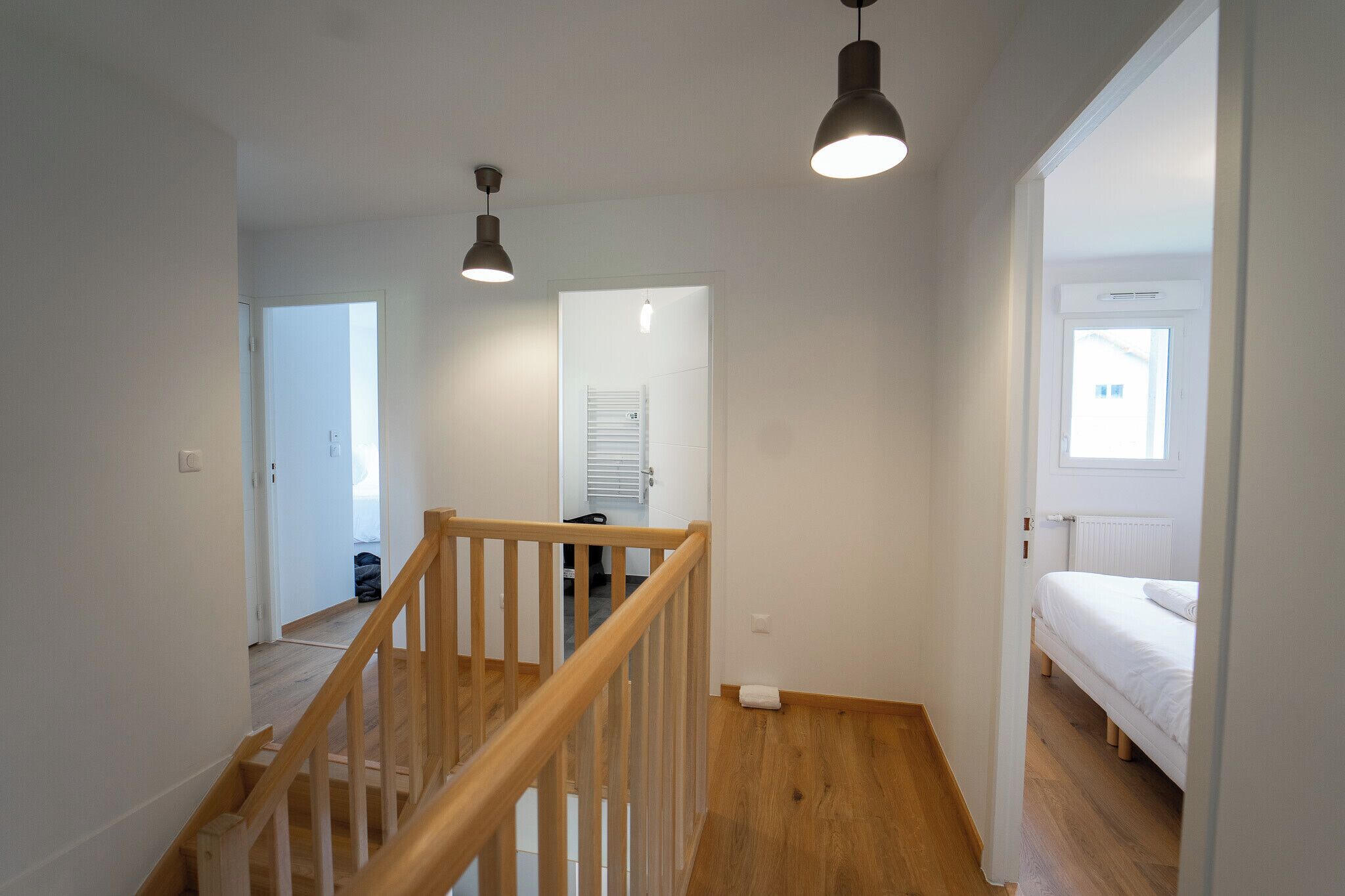 Eine Treppe führt zu einem Schlafzimmer mit einem Bett und einem Fenster.